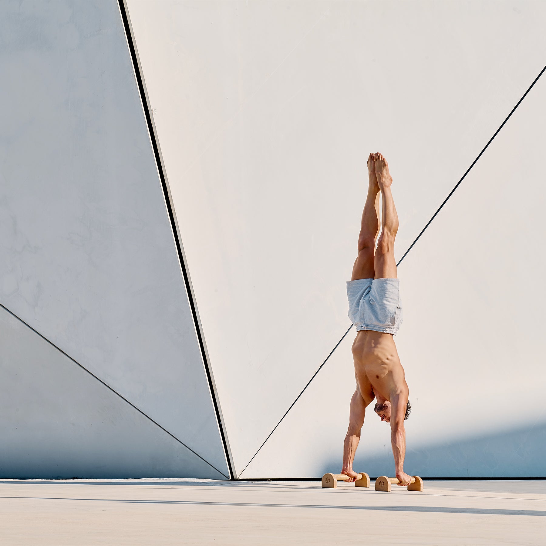 handstand auf hölzernen Paralletten